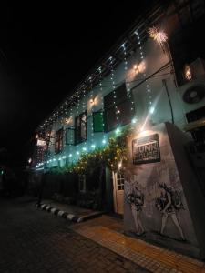 科钦Bunk house Fort Kochi的一座建筑物,晚上在建筑物的一侧有标志