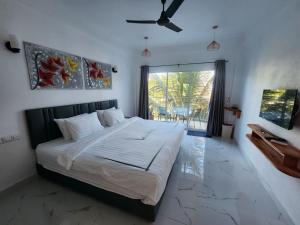 图杜Rihiveli Residence Thoddoo的一间卧室配有一张大床和吊扇
