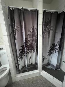汉堡Arsi Hostel的浴室设有棕榈树淋浴帘