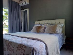 弗洛里亚诺波利斯Casa praia do Forte的卧室配有带枕头的床铺和窗户。