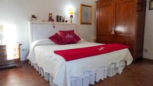 帕拉伊阿Appartamenti La Rocca的一间卧室配有一张带红色枕头的床