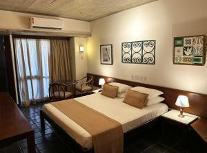 萨尔瓦多凯萨琳娜帕拉瓜库酒店的酒店客房设有一张大床和一张桌子。