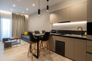 约阿尼纳d Suites and Apartments的厨房以及带桌椅的起居室。