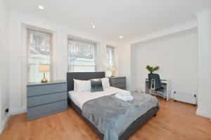 伦敦London Choice Apartments - Gloucester Road - Kensington的卧室配有一张床、一张书桌和窗户。