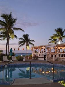 格雷斯湾西博恩海滩酒店 的棕榈树和海洋度假村的游泳池