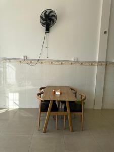 西哈努克Everest Restaurant and Guest House的一张带两把椅子的木桌和风扇