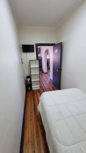 洛斯安赫莱斯Hostal Magnolia的卧室配有白色的床,铺有木地板