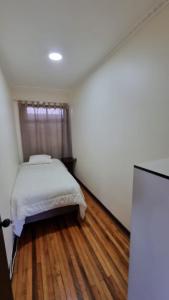 洛斯安赫莱斯Hostal Magnolia的一间卧室配有一张床,铺有木地板