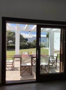卡拉莫若尔Villa d'Es Bot的玻璃门通向带桌椅的天井