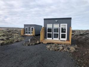 沃加尔Cozy mini house close to newest volcano and the ocean的坐在田野顶上的一个小房子