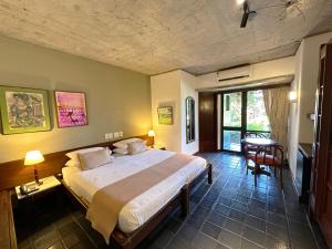 萨尔瓦多凯萨琳娜帕拉瓜库酒店的一间卧室配有一张大床和一张桌子