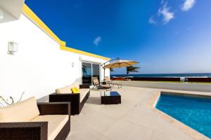 Long PathLovely 4-Bed Villa in Anguilla的户外庭院设有游泳池、椅子和遮阳伞。
