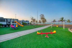 延布منتجع شاطئ الورد的草地上带玩具飞机的游乐场