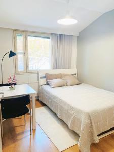 赫尔辛基Private rooms near metro, free parking的一间卧室配有一张床、一张书桌和一个窗户。