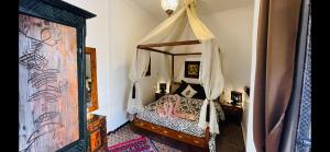 马拉喀什达尔纳贾特酒店的一间卧室,卧室内配有一张天蓬床