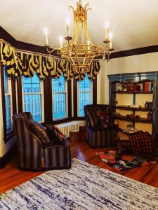 Fergus FallsMagnolia LLC short term rentals private room on the second floor的客厅配有皮椅和吊灯。