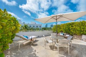 迈阿密海滩南海滩宾利酒店的庭院配有桌椅和遮阳伞。