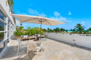 迈阿密海滩南海滩宾利酒店的庭院配有桌椅和遮阳伞。