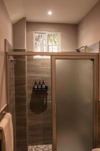 埃尔蒙特El Xalli的浴室内带玻璃门的步入式淋浴间