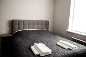 波尔塔瓦Гостьовий Будинок Апартаменти в тихому центральному районі Полтави Смарт-квартири的一间卧室配有一张床,上面有两条毛巾