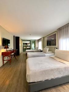 波哥大格雷西酒店的酒店客房设有三张床和一张书桌