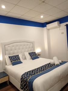 热那亚韦罗内塞酒店的卧室配有白色大床和蓝色的墙壁