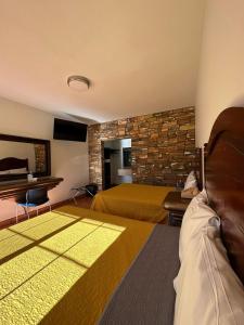 诺加利斯诺加利斯殖民地酒店的酒店客房设有两张床和石墙。