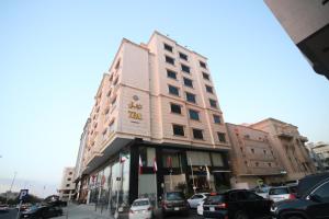 吉达فندق قصر توبال للشقق المخدومة的停车场内有车辆停放的高楼