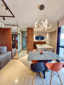 大坎普Vertigo Premium Studios - Luxo e Praticidade的客厅配有桌椅和1张床