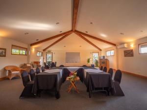 图克劳海滩卡灵顿庄园度假村的一间会议室,配有桌椅和黑板