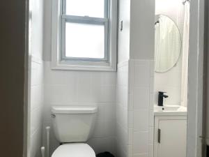 扬克斯2-A Diamond in Yonkers的白色的浴室设有卫生间和窗户。