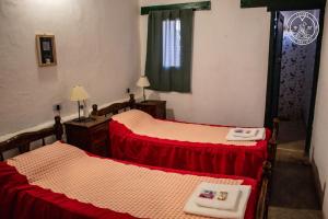 莫利诺斯El Progreso Molinos的配有红色和白色床单的客房内的两张床