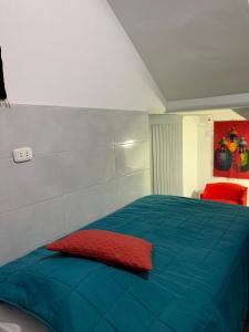 伊察Hamuy's Lodge的一间卧室配有一张蓝色的床和红色枕头