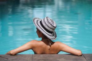 坎古Holiday Inn Resort Bali Canggu, an IHG Hotel的坐在游泳池旁戴帽子的女人