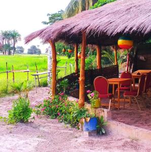 KachiouaneCampement Kaymba Lodge的田野上带桌椅的小屋