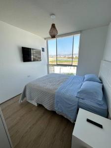 圣巴托洛Apartamento de estreno San Bartolo vista Piscina Playa的一间卧室设有一张床和一个大窗户