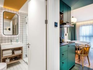 汉堡Aparthotel Adagio access Hamburg的一间带绿色橱柜和水槽的浴室