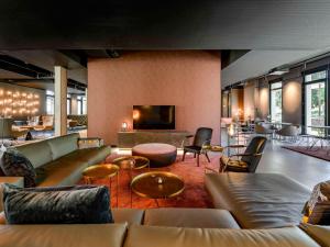 腓特烈港ibis Styles Friedrichshafen的带沙发和桌子的客厅以及电视。