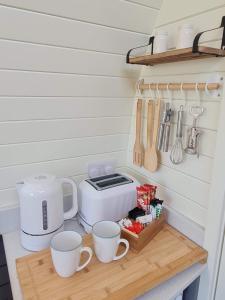 霍利黑德Two Peas in a Pod的厨房柜台配有杯子、烤面包机和餐具