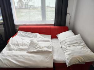 洛克尼册弗奥里克奥拉赫Apartmán Rokytnička的一张带白色床单和枕头的床,位于窗户前