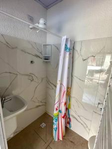 佩鲁伊比Casa aconchegante em Peruíbe的浴室配有淋浴帘和盥洗盆。