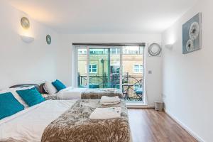 伦敦2&3 Bedrooms near EXCEL London - Modern Spacious Apartment For Larger Groups的一间带两张床的卧室和一个阳台