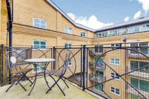 伦敦2&3 Bedrooms near EXCEL London - Modern Spacious Apartment For Larger Groups的大楼前的阳台配有桌椅