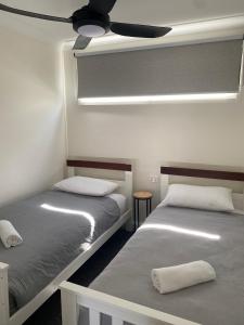 科罗瓦科罗瓦宾德瑞假日公园汽车旅馆的配有吊扇的客房内的两张床
