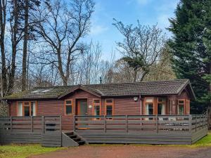 巴洛赫Kingfisher Lodge - Uk46046的小木屋前方设有围栏