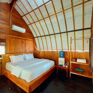 SelayarSunari Beach Resort 2的木制客房内的一间卧室,配有一张床