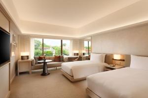 新加坡Conrad Singapore Orchard的酒店客房,设有两张床和一张沙发