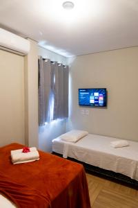 福廷Pousada Carcará的客房设有两张床和一台墙上的电视。