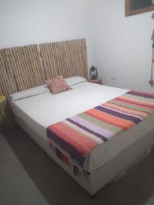 San RoqueCASITA PINTORESCA EN LAS SIERRAS Y LAGO的床上有条纹毯子