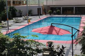 华阴华山欣源国际酒店的一座大型游泳池,里面装有粉红色的遮阳伞